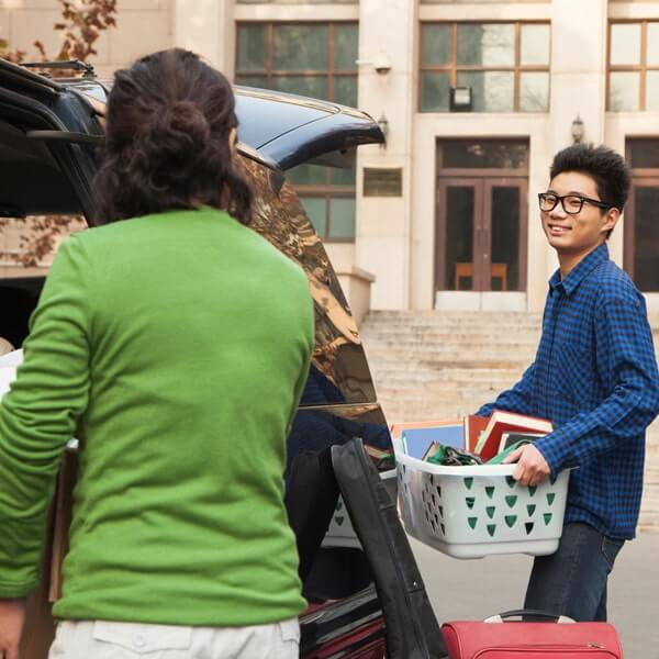 person packing a white laundry basket